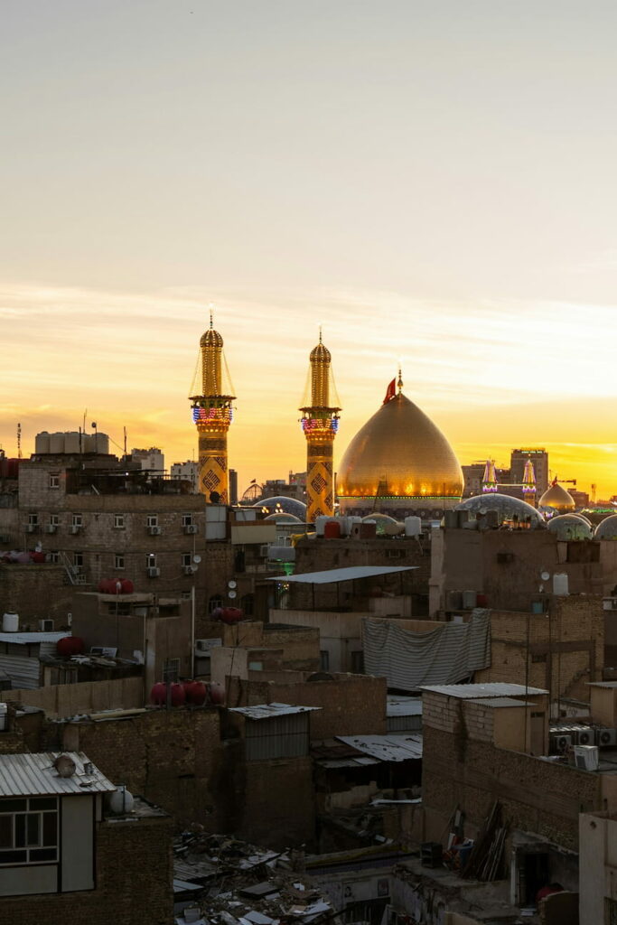 The skyline of the city of Karbala at sunset, showing the shrine of Imam Hussein.
