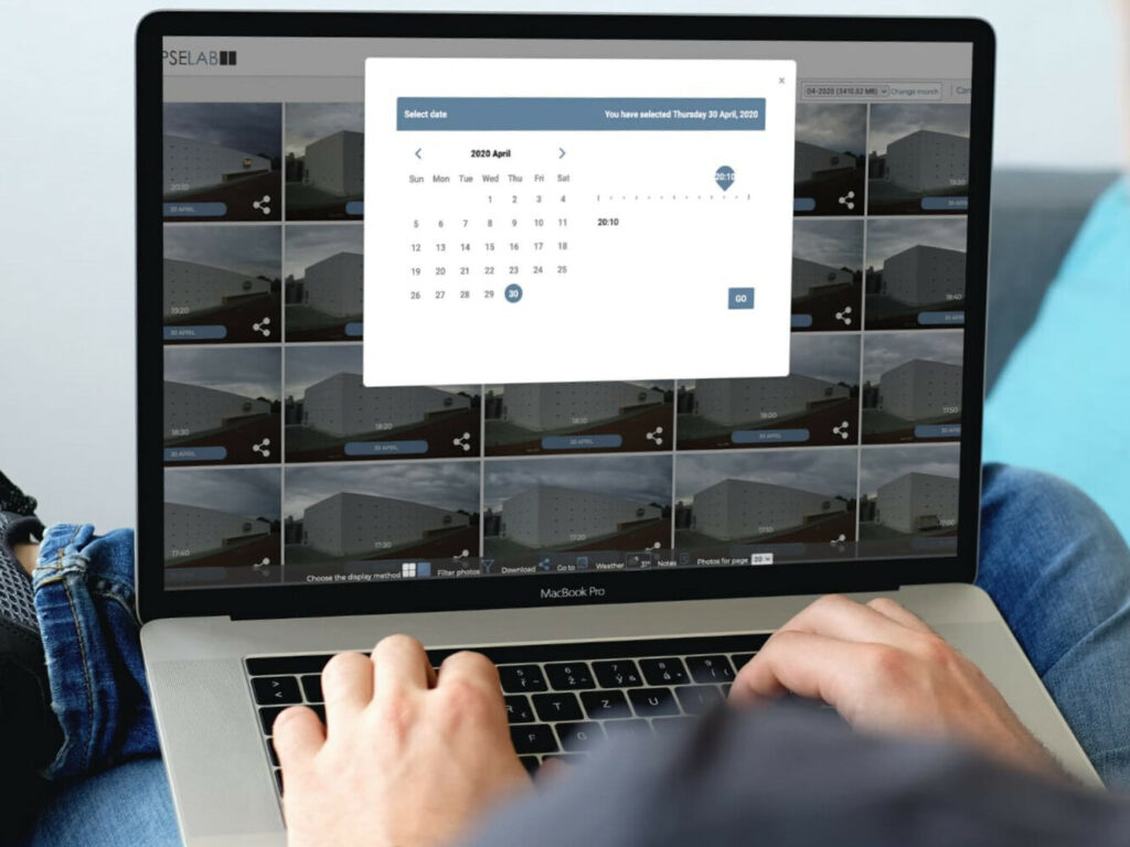 A Timelapselab construction work monitoring panel is displayed on a laptop.